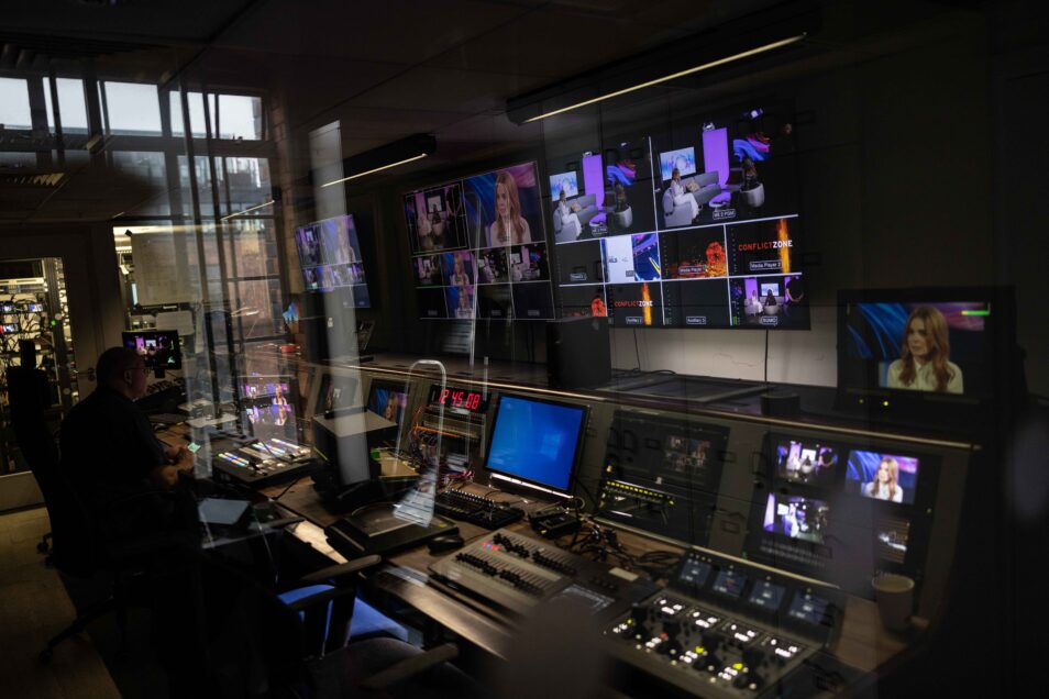 Television production gallery with video monitors and desk of broadcast equipment in london content studio